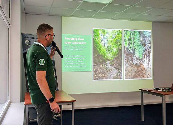 Referaty Mężczyzna prezentuje informacje przed ekranem, na którym wyświetlane są slajdy